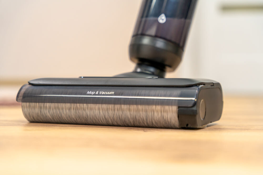 Odkurzacz mopujący GÖTZE & JENSEN VM500 Zbliżenie na stopę mopującą odkurzacza GÖTZE & JENSEN VM500 z napisem Mop & Vacuum oraz obrotowy wałek czyszczący.