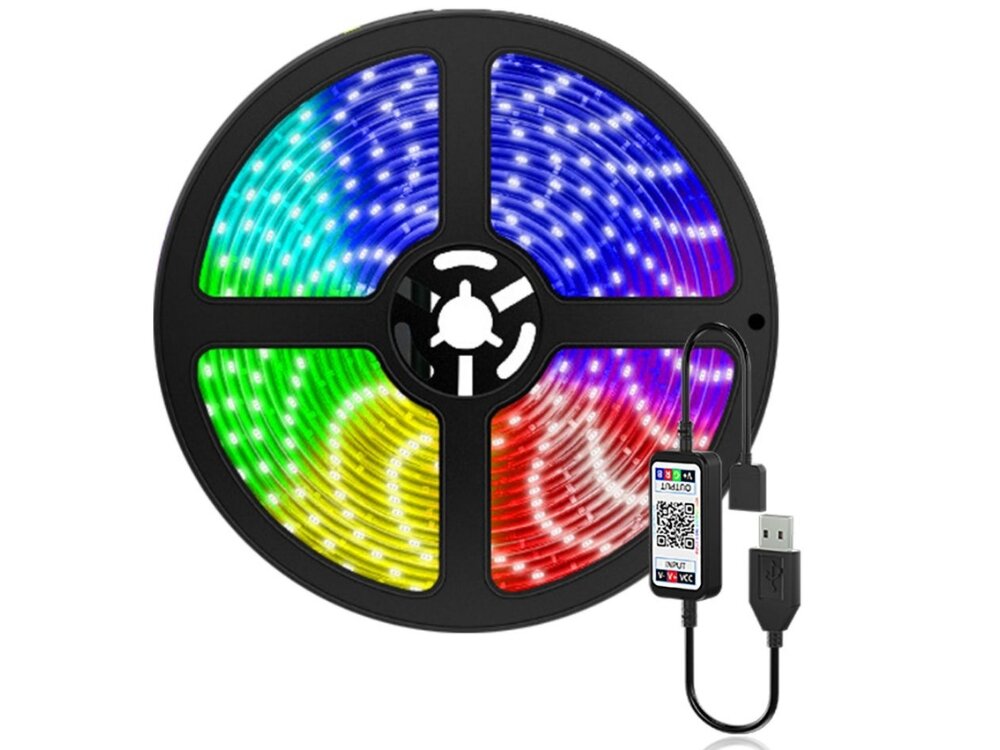 Obraz przedstawia zwiniętą taśmę LED RGB w kolorach niebieskim, zielonym, żółtym i czerwonym, z podłączonym kablem USB. Na kablu widoczny jest mały moduł z kodem QR i oznaczeniami \'INPUT\' oraz \'OUTPUT\'.