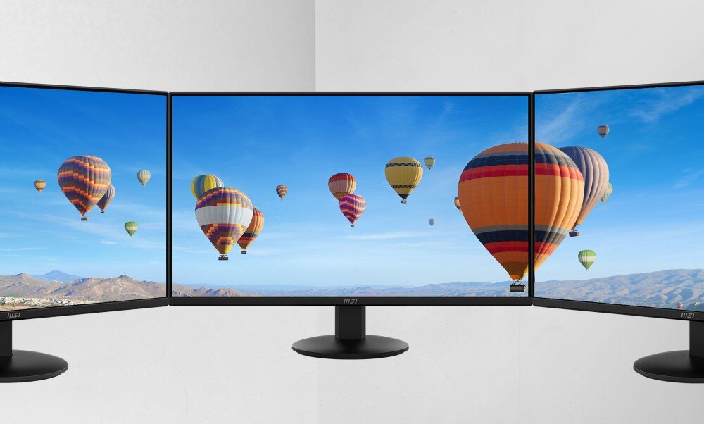 Monitor MSI Pro MP272L Trzy monitory ustawione obok siebie, na ekranach widoczne balony unoszące się nad krajobrazem górskim, ramka, grubość, konstrukcja