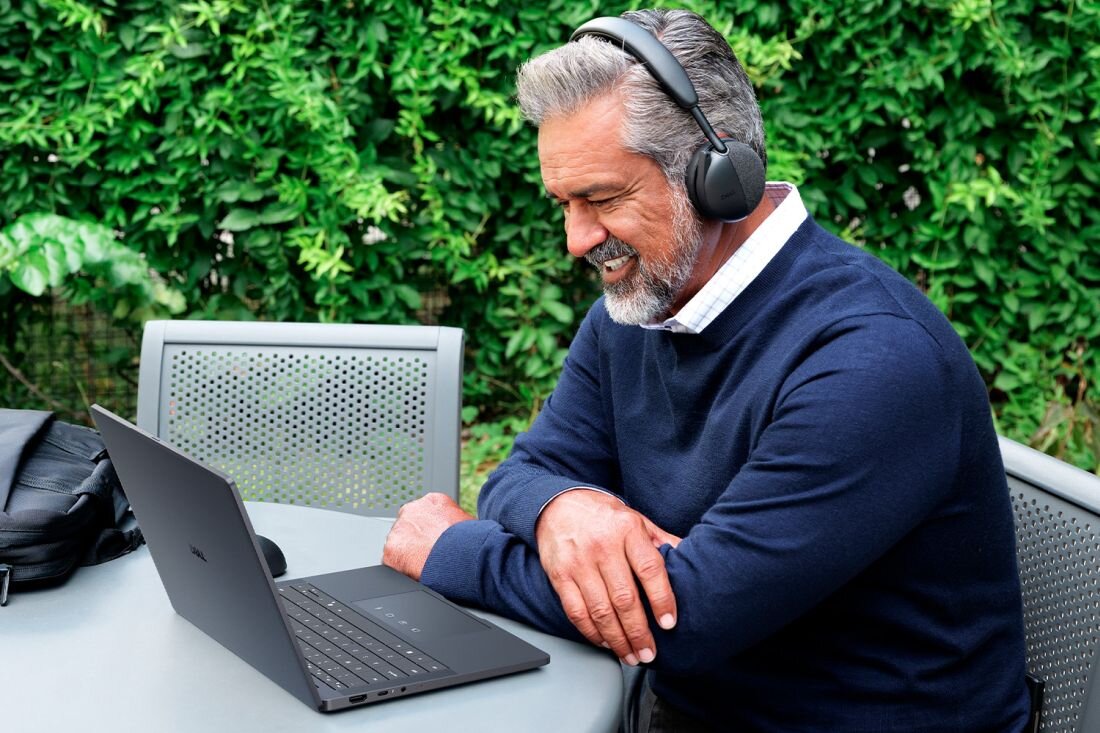 Osoba korzysta z laptopa Dell Pro z długim czasem pracy na baterii przy stoliku na zewnątrz podczas pracy zdalnej.