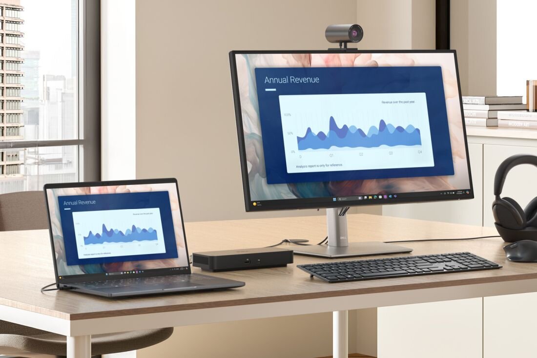 Laptop Dell Pro Premium z Thunderbolt podłączony do monitora i stacji dokującej pokazuje wykresy przy biurku w pracy biurowej.