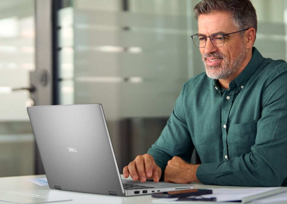 Mężczyzna korzysta z laptopa DELL Pro 14 Plus PB14250 BTO212 przetwarzając dane w cichym przeszklonym biurze – pamięć LPDDR5X dysk SSD 512 GB PCIe NVMe
