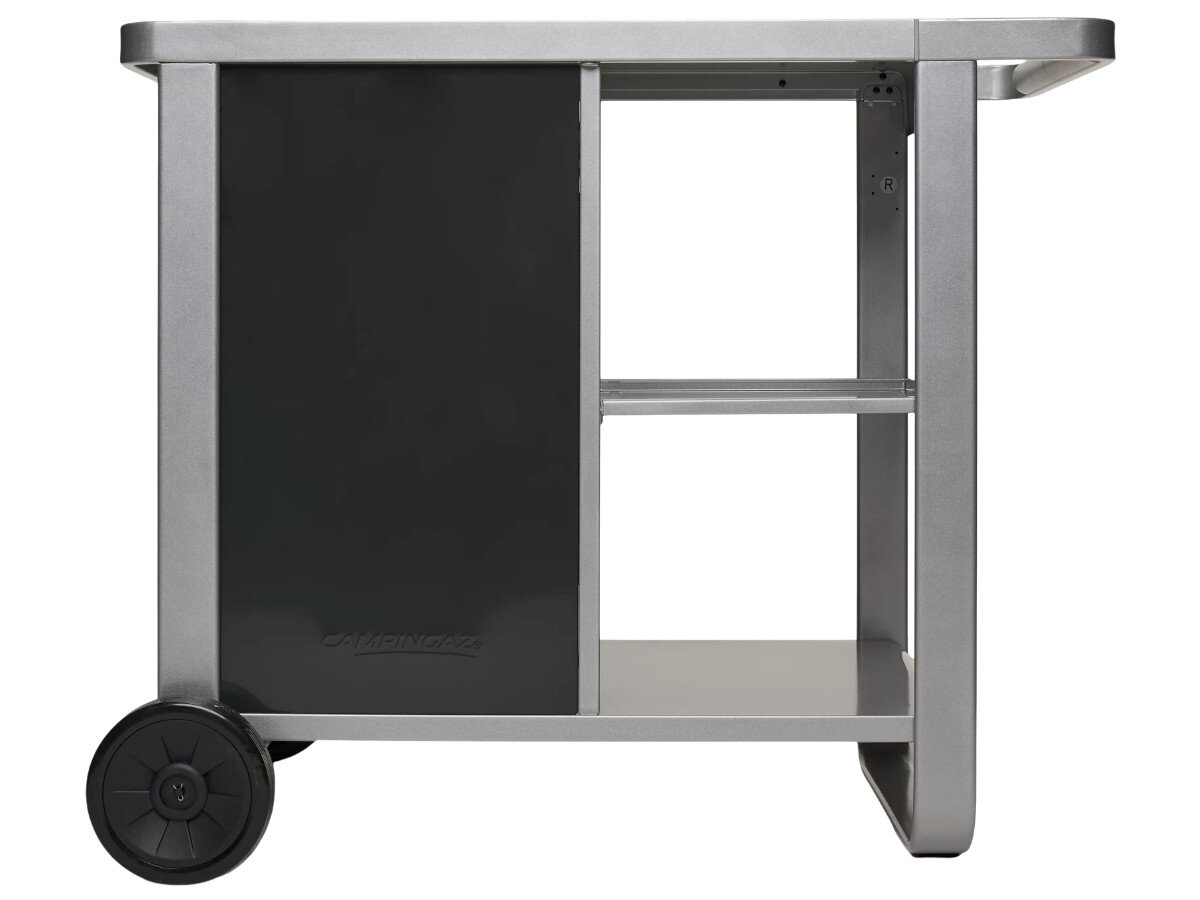 Wózek do grilla CAMPINGAZ Plancha Deluxe 2213920, stal, wymiary, stabilność, trwałość,  Detal drzwi szafki wózka kuchennego – czarne matowe drzwi na srebrnej ramie z logo producenta i kołem.