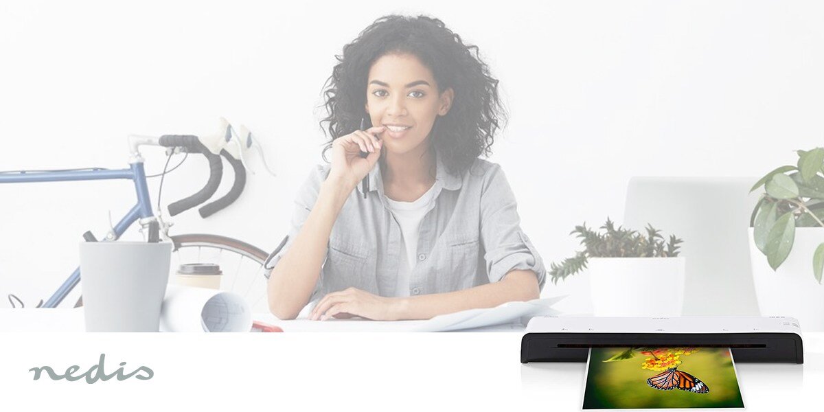 Folia do laminowania NEDIS LAMIA4AT100 A4, 100 mic (100 szt.) prezentacja folii wychodzącej z laminatora w tle kobieta siedząca przy biurku jasne tło i rower 100 folii A4 długotrwałe korzystanie biuro szkoła punkt usługowy