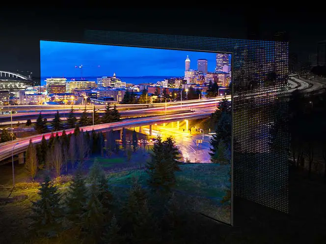 Wyświetlane jest miasto oświetlone jasnymi światłami. Kolory i światła są żywe, jak pokazuje OLED przez ekran QuantumDot.