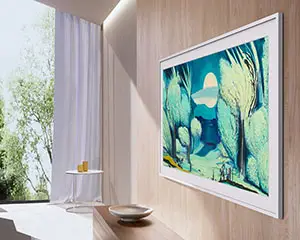 Na ścianie, pod kątem, wisi Samsung The Frame z niebieskim obrazem malarskim w ekranie.