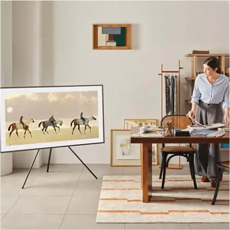 448x448 stojak-studio Telewizor Samsung The Frame (2025) stoi na stojaku przy stole z pracującą kobietą