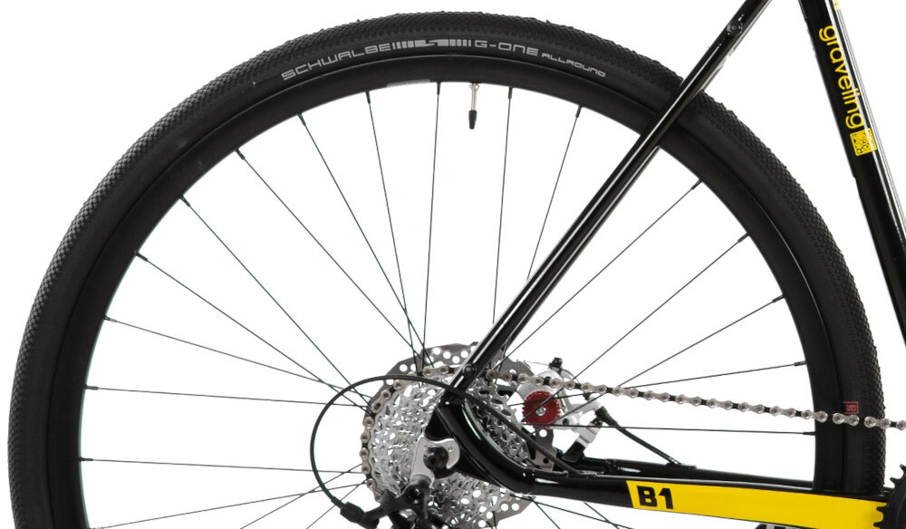 Rower gravel ROMET Boreas 1 U22 28 cali Czarno-żółty zbliżenie na tylną oponę rozmiar koła 28 cali opony SCHWALBE bardzo dobra przyczepność trwałość komfort jazdy aluminiowe obręcze Alexrims ATD550 stabilne trzymanie opony sprzęt do wyczynowego kolarstwa szybkiego regularne sprawdzanie ciśnienia powietrza wartość na bocznej części opony