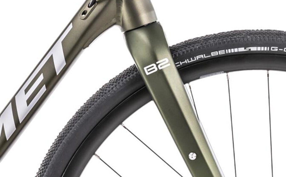 Rower gravel ROMET Boreas 2 U23 28 cali Zielono-grafitowy 2023 zbliżenie na widelec widelec z włókna węglowego o konstrukcji tapered podnosi komfort i jakość jazdy zwężona rura sterowa sztywność i stabilność prowadzenia tłumi drobne drgania z nawierzchni ułatwia przyspieszanie i ogranicza zmęczenie ramion