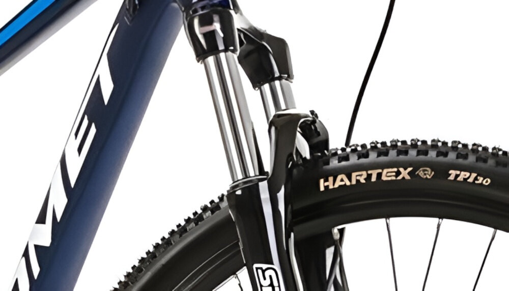 Rower górski MTB ROMET Mustang M7.1 U21 27.5 cala Ciemnoniebieski zbliżenie na amortyzator rower typu hardtail przedni amortyzator marki SUNTOUR typ XCT długość skoku 100 mm ułatwia najeżdżanie na przeszkody niweluje wstrząsy niska masa roweru duża sztywność regulacja za pomocą sprężyny obsługa poprzez manetkę