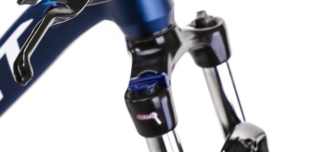 Rower górski MTB ROMET Mustang M7.1 U17 27.5 cala Ciemnoniebieski zbliżenie na amortyzator rower typu hardtail przedni amortyzator marki SUNTOUR typ XCE długość skoku 100 mm ułatwia najeżdżanie na przeszkody niweluje wstrząsy niska masa roweru duża sztywność regulacja za pomocą sprężyny obsługa poprzez pokrętło na goleni