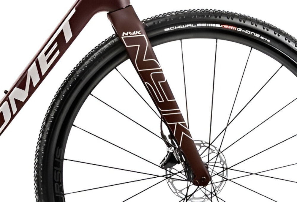 Rower gravel ROMET Nyk U22 28 cali Brązowo-beżowy 2024 zbliżenie na widelec białe tło karbonowy widelec marki ROMET skutecznie tłumi drgania komfort jazdy jest wyraźnie wyższy włókno węglowe lepsza precyzja prowadzenia większa kontrola szybsza reakcja na ruchy kierownicy