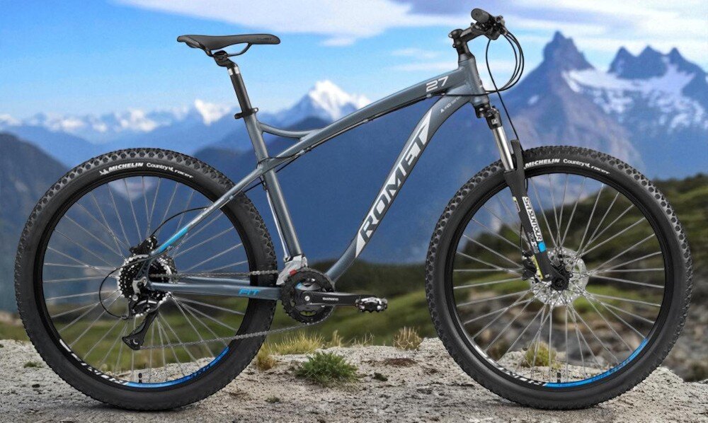 Rower górski MTB ROMET Rambler Fit U18 27.5 cala Czarno-srebrno-niebieski rower na tle gór nieba środek codziennego transportu relaks pasja uniwersalność