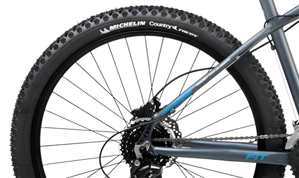 Rower górski MTB ROMET Rambler Fit U18 27.5 cala Czarno-srebrno-niebieski zbliżenie na oponę rozmiar koła 27,5 cali łatwe pokonywanie przeszkód duży kontakt koła z podłożem szerokie opony marki MICHELIN dobra przyczepność dwukomorowe aluminiowe obręcze zachowanie regularnego kształtu kół stabilne trzymanie opony bezpieczna i komfortowa jazda regularne sprawdzanie ciśnienia powietrza wartość na bocznej części opony