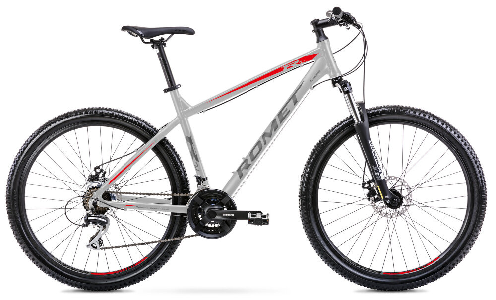 Rower górski MTB ROMET Rambler R7.1 U21 27.5 cala Srebrno-czerwono-grafitowy rower na białym tle widoczny od przodu po skosie góral pojazd dla sportowców do jazdy wyczynowej uniwersalny dla amatorów zwrotny łatwo wchodzi w zakręty do jazdy w mieście za miastem w lesie na górskim szlaku w błocie nie za głębokim piachu