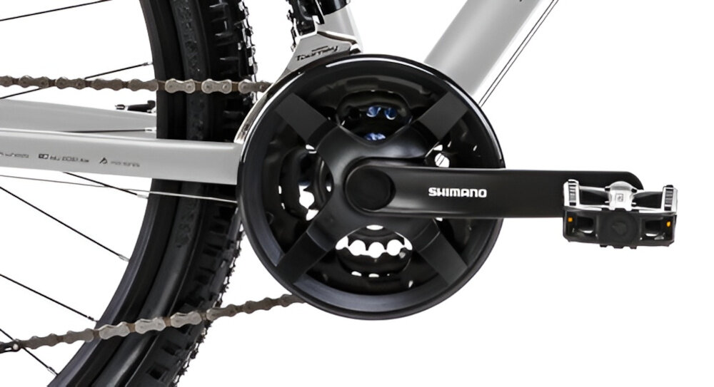 Rower górski MTB ROMET Rambler R7.1 U21 27.5 cala Srebrno-czerwono-grafitowy zbliżenie na korbę kasetę i łańcuch lekka wydajna konstrukcja korby korba SHIMANO Tourney typu TY301 24/34/42 x 170 mm kaseta SHIMANO typu MF-TZ500 14-28T, 7 biegów solidność wytrzyma bardzo duży nacisk na pedały