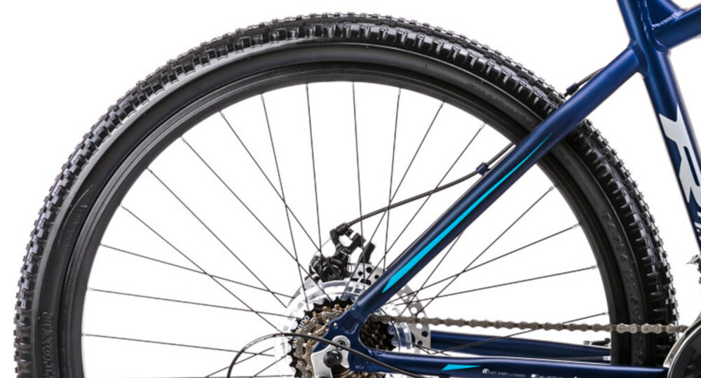 Rower górski MTB ROMET Rambler R7.1 V2 U19 27.5 cala Granatowy zbliżenie na oponę rozmiar koła 27,5 cali łatwe pokonywanie przeszkód duży kontakt koła z podłożem szerokie opony dobra przyczepność dwukomorowe aluminiowe obręcze zachowanie regularnego kształtu kół stabilne trzymanie opony bezpieczna i komfortowa jazda regularne sprawdzanie ciśnienia powietrza wartość na bocznej części opony