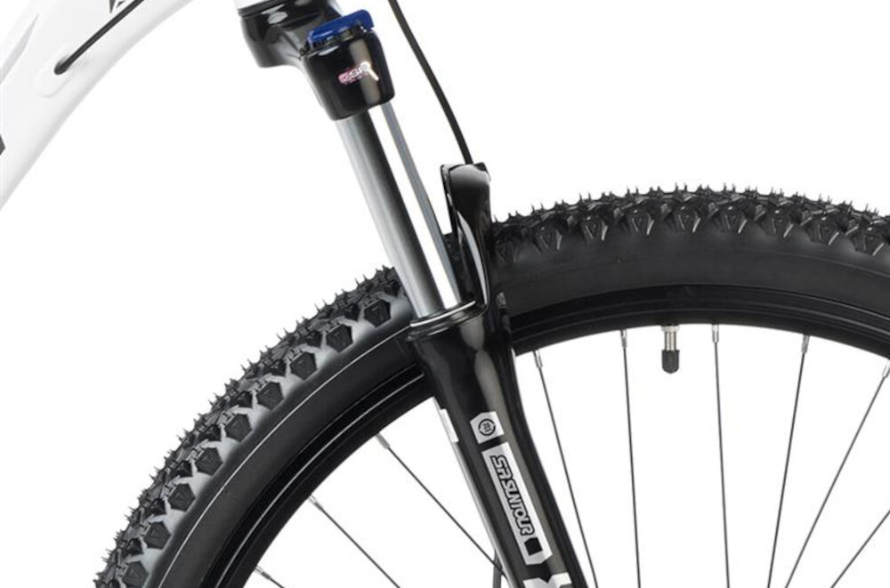 Rower górski MTB ROMET Rambler R7.4 U18 27.5 cala Biało-złoty zbliżenie na amortyzator rower typu hardtail przedni amortyzator marki SUNTOUR typ SR XCT DS HLO długość skoku 100 mm ułatwia najeżdżanie na przeszkody niweluje wstrząsy niska masa roweru duża sztywność regulacja za pomocą sprężyny obsługa poprzez pokrętło na jednej z goleni