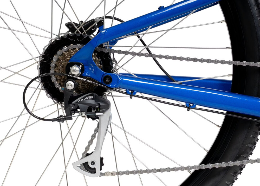 Zbliżenie na tylne koło niebieskiego roweru z widocznym mechanizmem przerzutki i łańcuchem. Przerzutka ma napis \'Alivio\'.