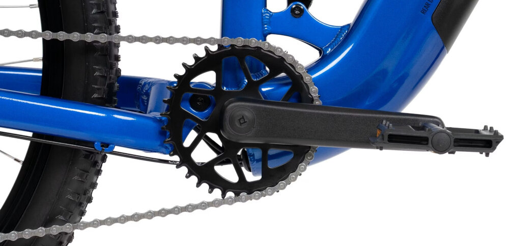 Zbliżenie na mechanizm napędowy roweru z czarną korbą i łańcuchem na niebieskiej ramie.