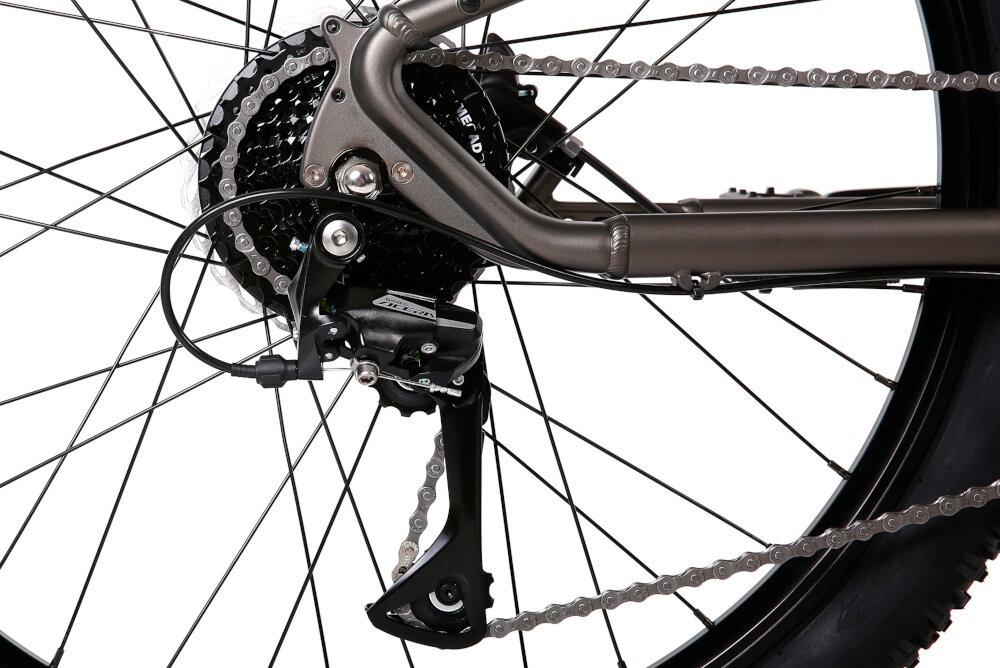 Rower elektryczny ROMET E-Rambler JR 1.0 504 U12 26 cali Grafitowy zbliżenie na przerzutkę manetki SHIMANO typu M315 8 biegów tylna przerzutka SHIMANO Acera duża wytrzymałość sprawne działanie zmiana biegów jest płynna i bezproblemowa