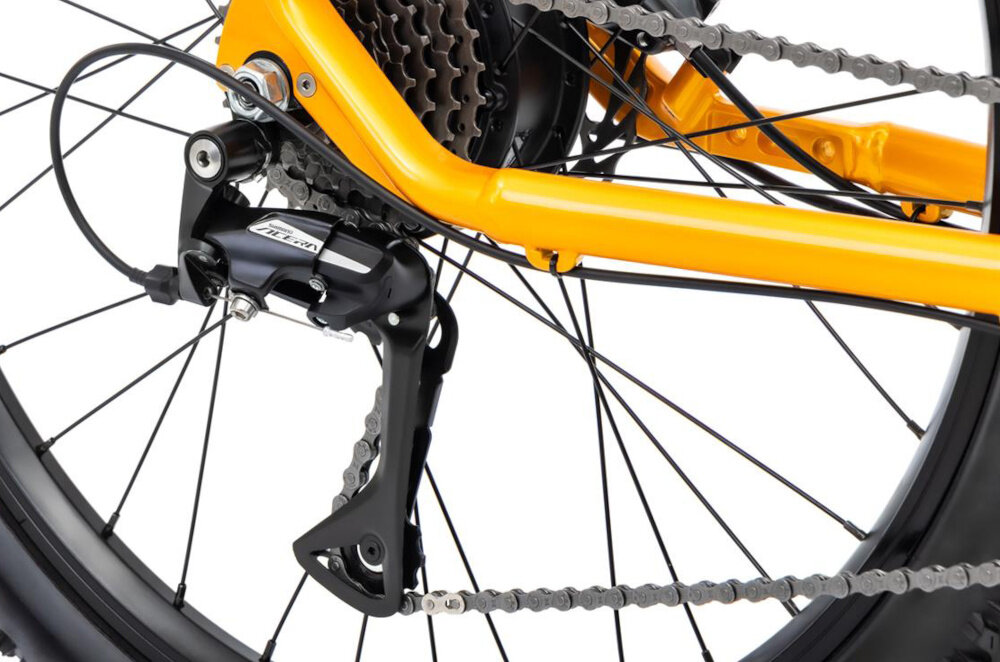 Rower elektryczny ROMET E-Rambler JR 1.0 504 U12 26 cali Pomarańczowy zbliżenie na przerzutkę manetki SHIMANO typu M315 8 biegów tylna przerzutka SHIMANO Acera duża wytrzymałość sprawne działanie zmiana biegów jest płynna i bezproblemowa