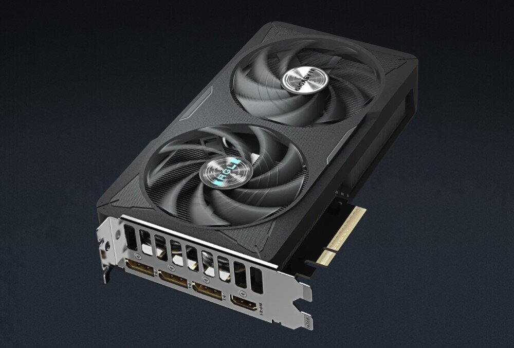 Karta graficzna GIGABYTE GeForce RTX 5060 Eagle OC 8GB Zbliżenie na system chłodzenia karty pod dużym kątem, pokazujące detale łopatek wentylatorów z wypustkami aerodynamicznymi oraz fakturę obudowy, porty, wyjścia wideo