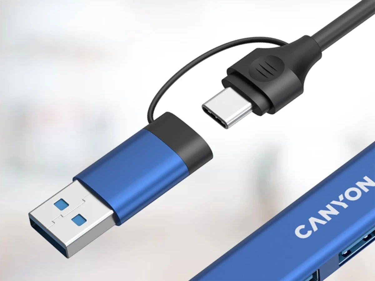 Na obrazie widoczny jest niebieski hub USB z logo \'CANYON\'. Hub posiada złącza USB-A i USB-C oraz czarny kabel.