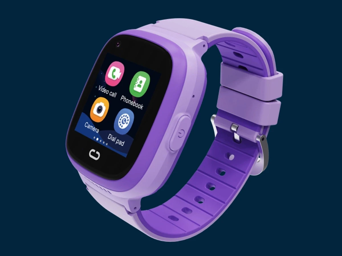 Fioletowy smartwatch z kolorowym wyświetlaczem, na którym widoczne są ikony aplikacji: Video call, Phonebook, Camera, Dial pad. Pasek zegarka jest również fioletowy z metalowym zapięciem.
