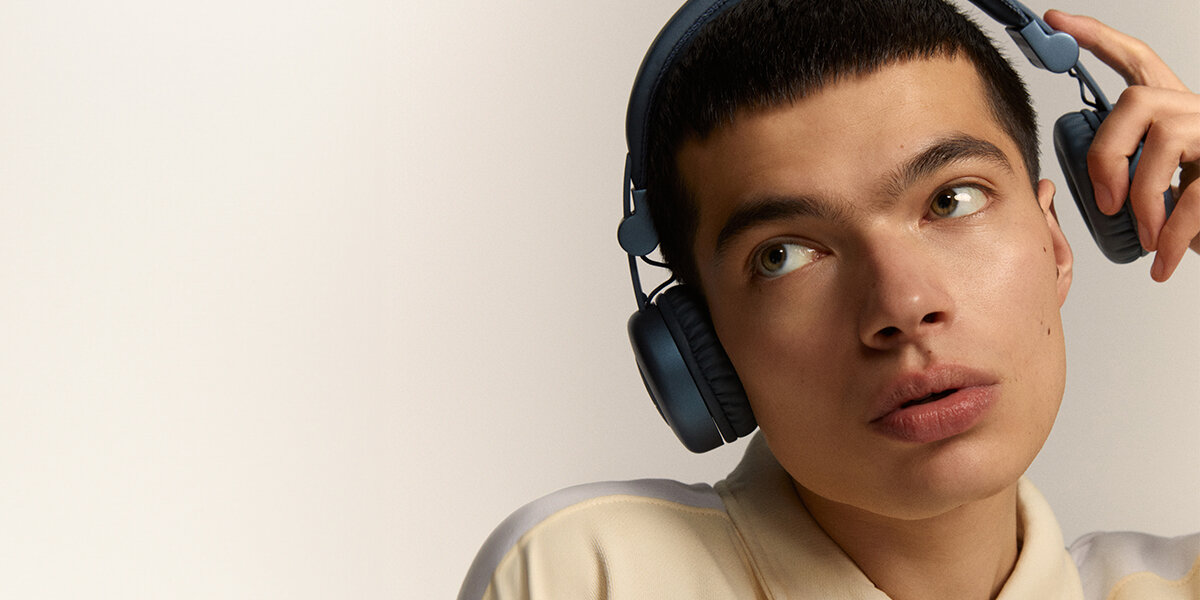 Słuchawki nauszne FRESH N REBEL Code Core Słuchaj bez przewodów, przyciski z boku, osoba mająca założone słuchawki na głowie