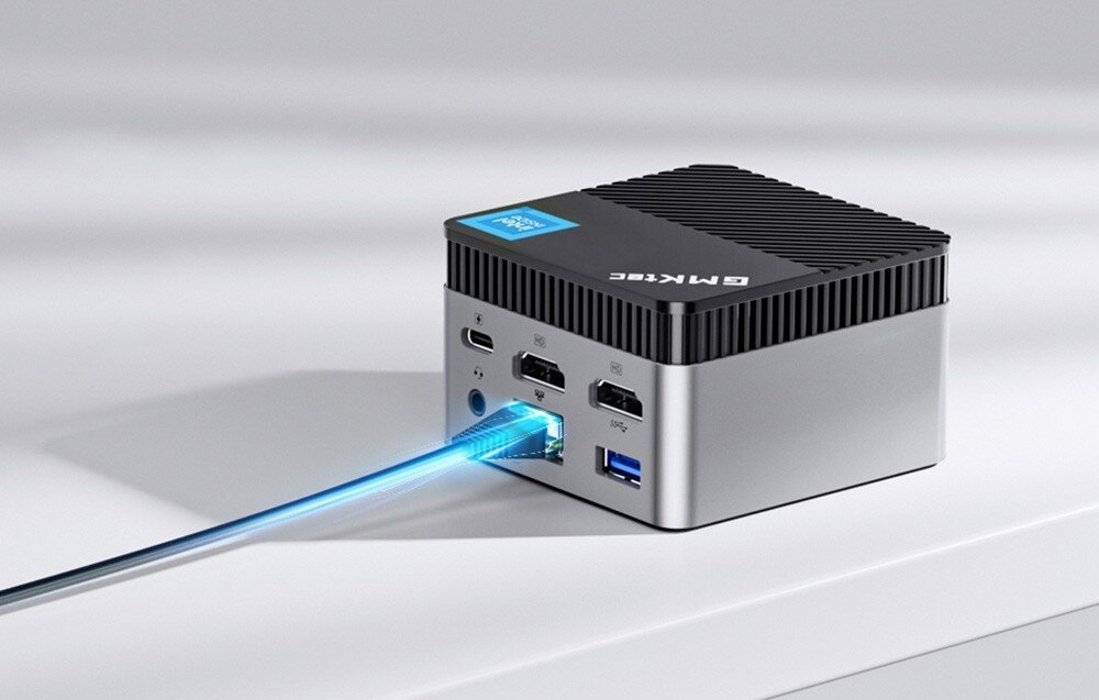 Komputer GMKTEC G5 Tylna część małego szarego komputera z podłączonym kablem sieciowym i widocznymi portami HDMI, USB i Ethernet, łączność bezprzewodowa, Wi-Fi, Bluetooth