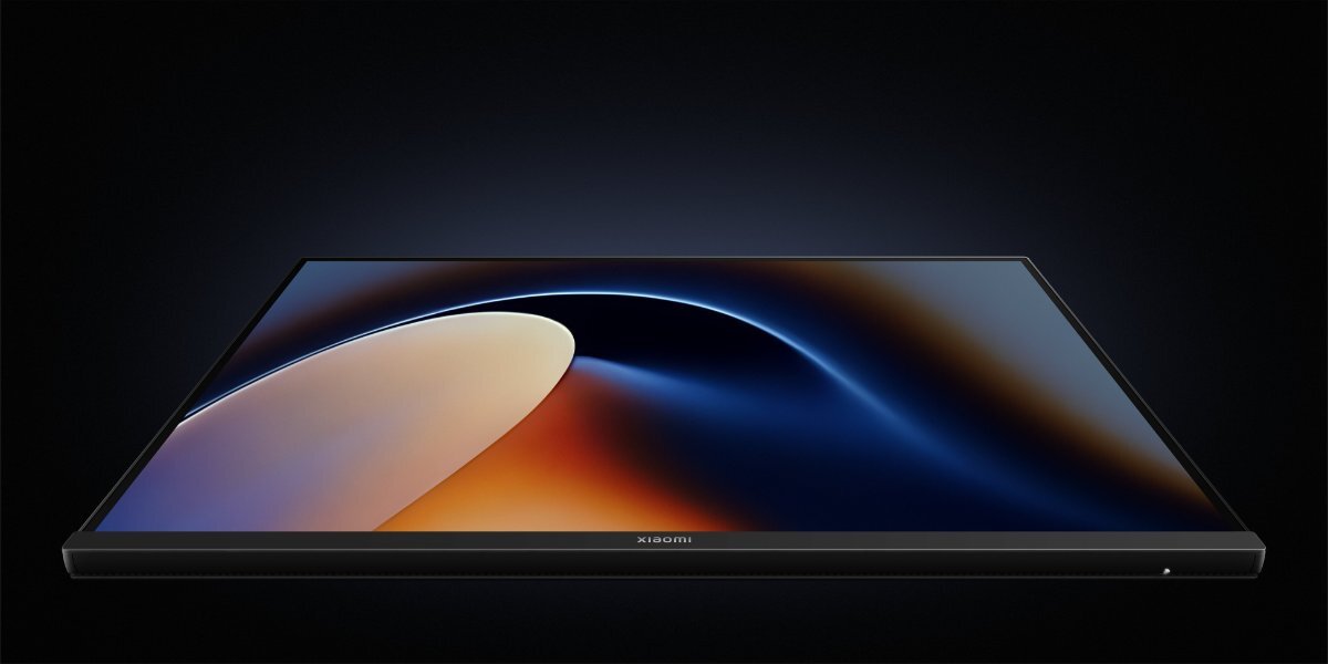 Monitor z cienkimi ramkami, wyświetlający abstrakcyjny obraz w odcieniach niebieskiego i pomarańczowego. Na dolnej ramce widoczne jest logo \'xiaomi\'.