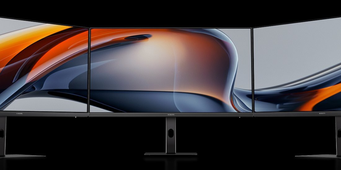 Trzy monitory XIAOMI obok siebie na białym tle.
