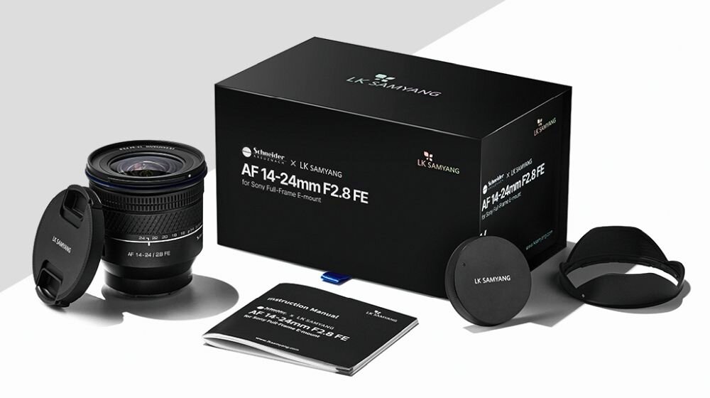 Na obrazie znajduje się obiektyw fotograficzny z założonym dekielkiem, pudełko z napisem \'AF 14-24mm F2.8 FE\', instrukcja obsługi oraz dodatkowe akcesoria. Logo na pudełku to \'LK SAMYANG\'.
