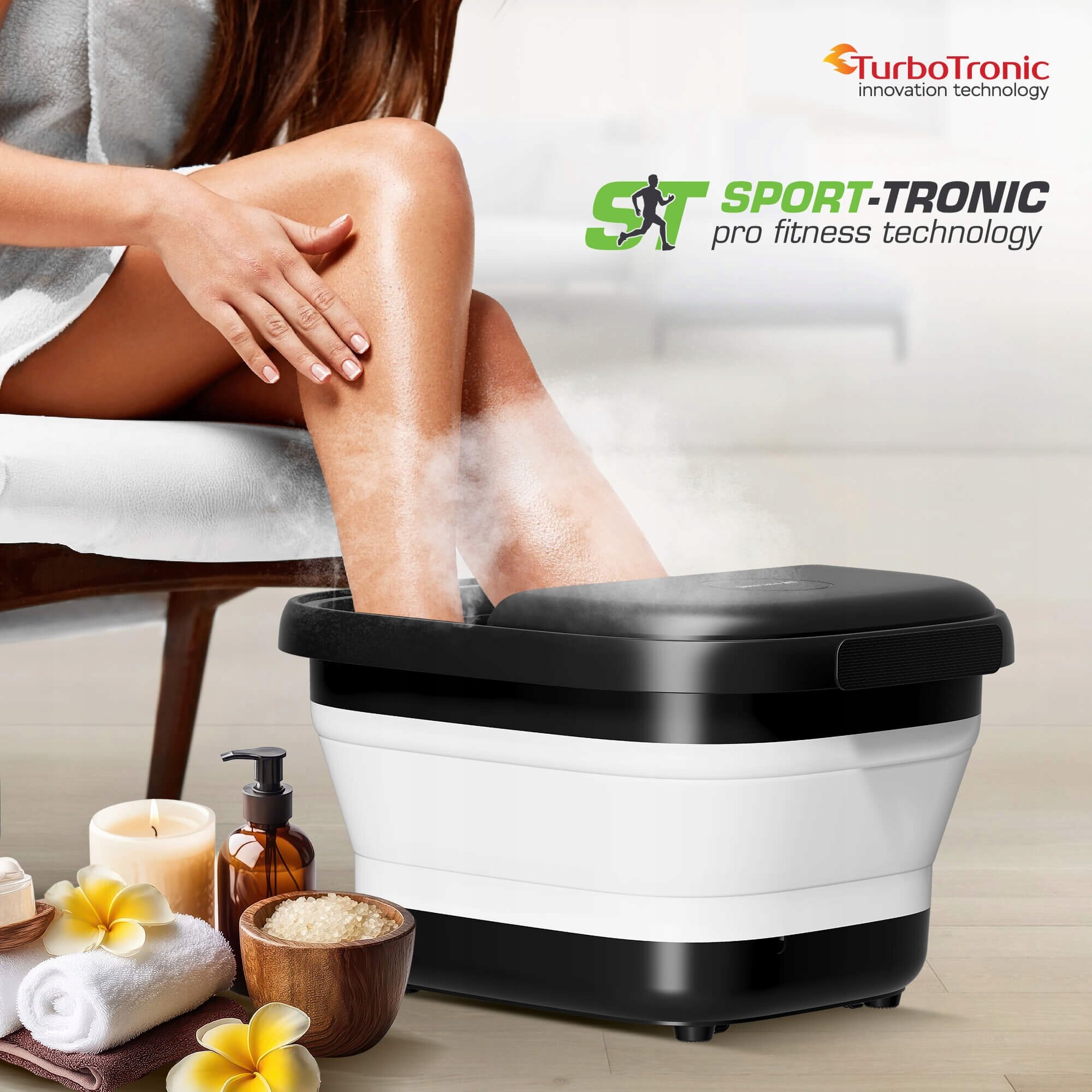 Osoba korzysta z wodnego masażera do stóp, z którego unosi się para. Na obrazie widoczne są również ręczniki, świeca, kwiaty oraz logo TurboTronic i napis \'SPORT-TRONIC pro fitness technology\'.