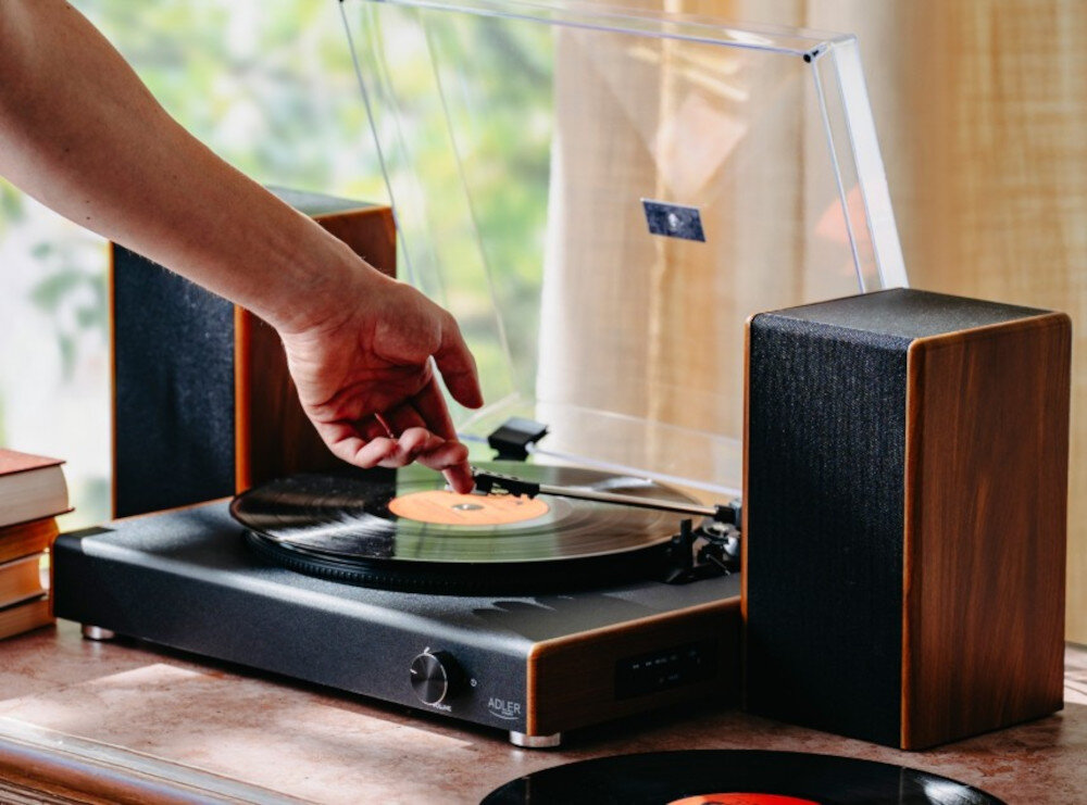 Gramofon ADLER AD 1915 głośniki stereo 2x10W odsłuch bez dodatkowego sprzętu, gramofon stojący na komodzie, ręka przytrzymująca igłę
