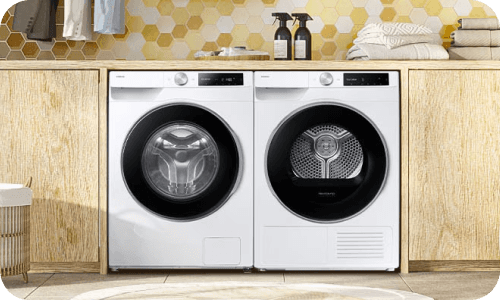 Pralka i suszarka umieszczone obok siebie w nowoczesnej łazience z drewnianymi akcentami.