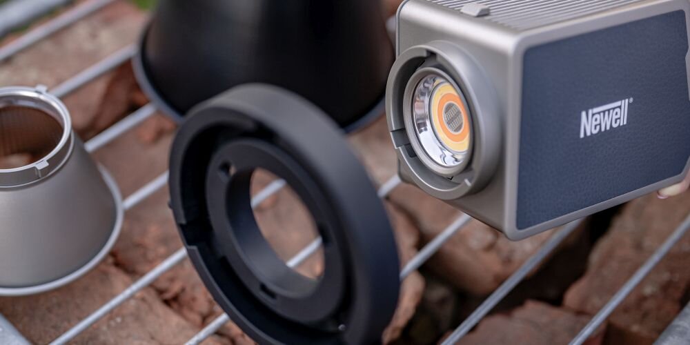 Zbliżenie na srebrną lampę LED Newell z widoczną diodą oraz czarny pierścień montażowy na kratce.