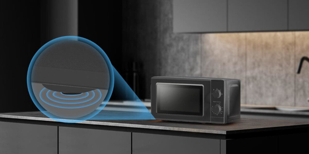 Czarna kuchenka mikrofalowa stoi na blacie kuchennym, obok niej widoczna jest grafika przedstawiająca technologię inwerterową. Kuchenka ma dwa pokrętła i duże okno na drzwiczkach.