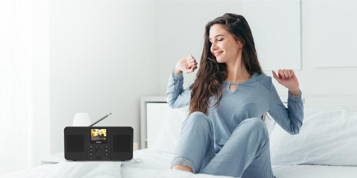 Radio HAMA DIR10 - Budzik z personalizacją, dwa budziki, radio stojące na stoliku obok łóżka, osoba wstająca z łóżka