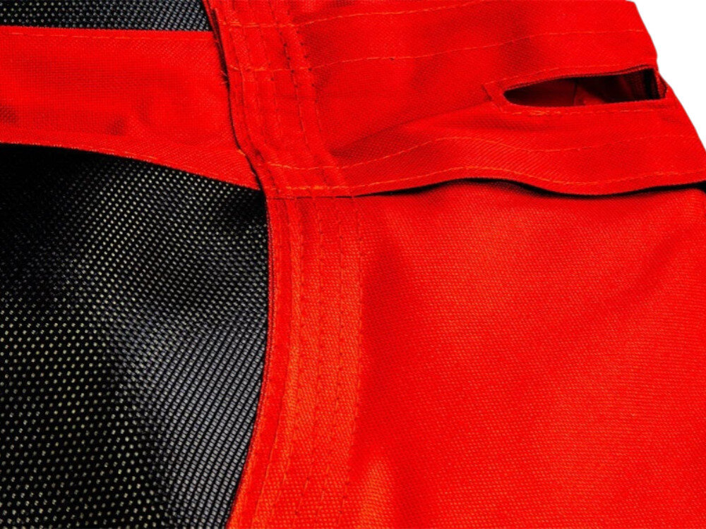 Zbliżenie na materiał huśtawki ogrodowej w kolorze czerwonym z czarnymi elementami siatki. Widoczne są szwy i otwory w materiale.