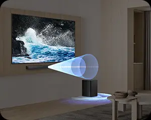 W salonie znajduje się telewizor z wyświetlanym obrazem fal morskich oraz soundbar i subwoofer na podłodze. Z subwoofera emanuje niebieskie światło w kształcie stożka.