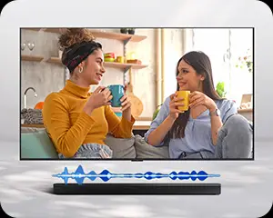 Na ekranie telewizora dwie osoby siedzą na kanapie, trzymając kubki. Przed telewizorem znajduje się czarny soundbar z niebieskim wykresem fal dźwiękowych.