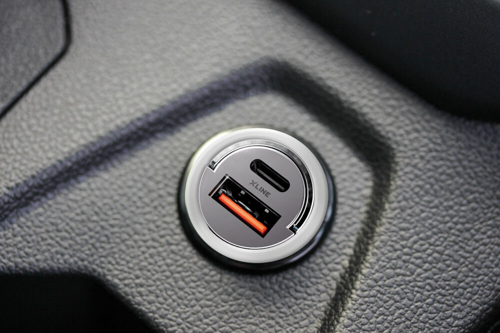 Ładowarka samochodowa XLINE CCT300 30W Szary Kompaktowa ładowarka samochodowa XLINE umieszczona w gnieździe zapalniczki, widok na panel z portem USB oraz USB-C Power Delivery.