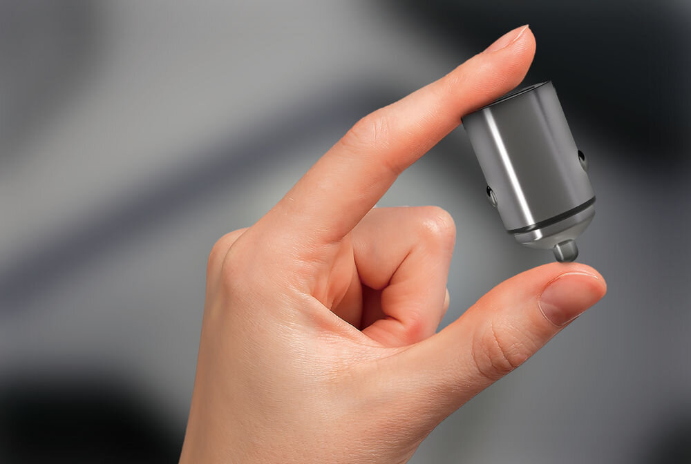 Ładowarka samochodowa XLINE CCT300 30W Szary Mała ładowarka samochodowa XLINE trzymana w dwóch palcach, prezentująca miniaturowy rozmiar typu nano.