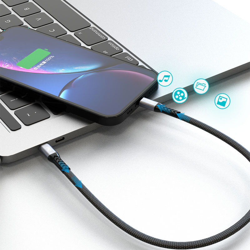Czarny kabel podłączony do laptopa i smartfona, z ikonami muzyki, folderu, filmu i zdjęcia unoszącymi się obok. Na ekranie smartfona widoczny jest wskaźnik ładowania z napisem w języku chińskim oraz 100%.