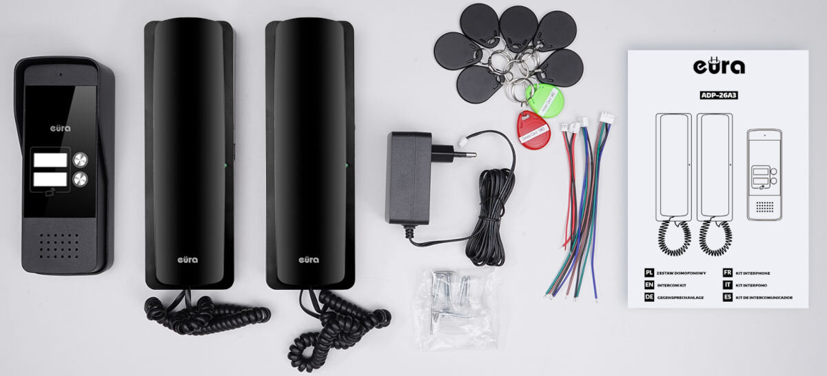 Domofon EURA ADP-26A3 Czarny, zestaw, montaż, komplet, kompatybilność, Kompletny zestaw dwurodzinnego domofonu Eura – czarna kaseta bramowa z dwoma przyciskami, dwa białe unifony, zasilacz, breloki RFID, przewody, elementy montażowe i instrukcja obsługi ułożone na jasnym tle.