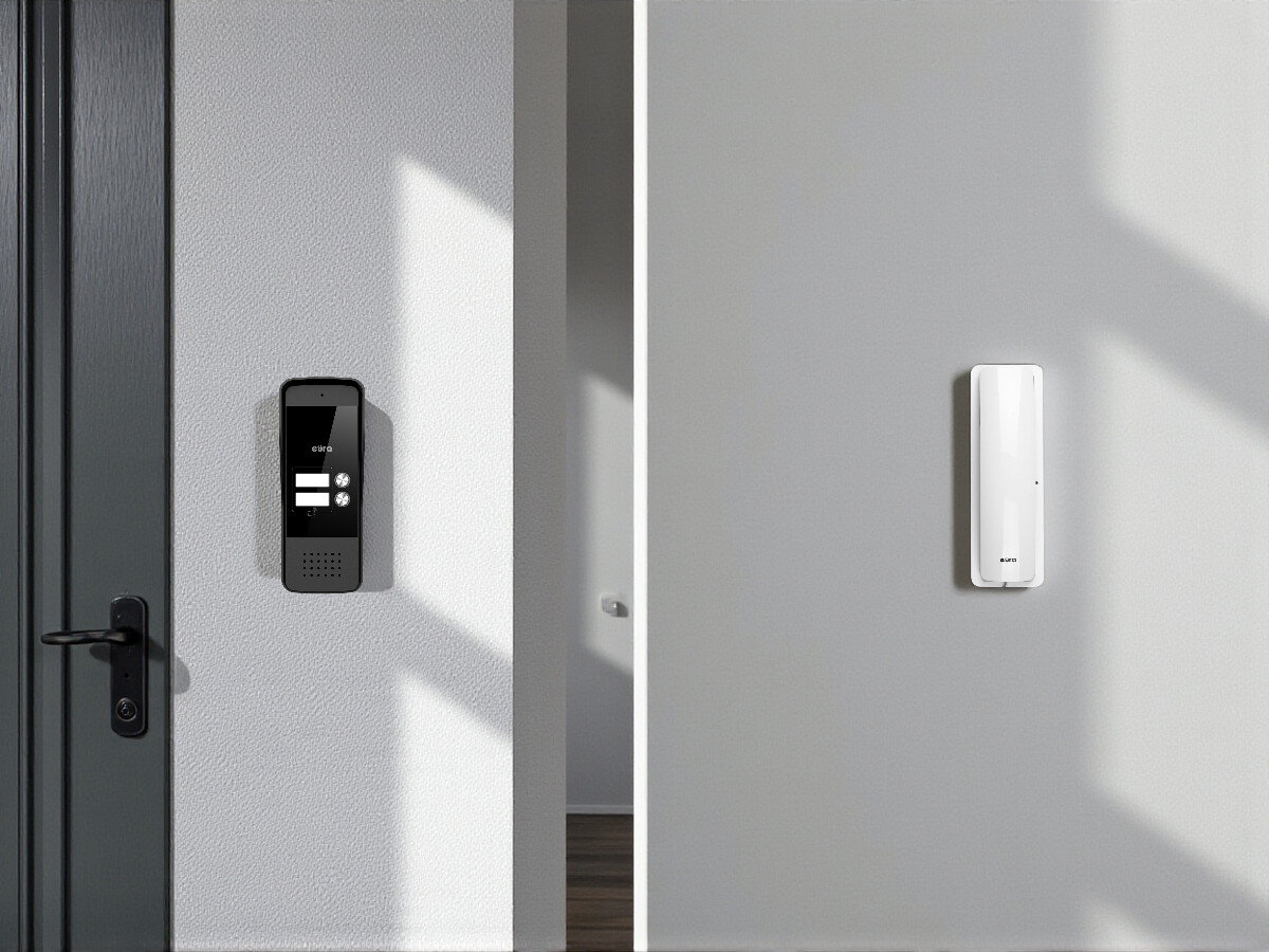 Domofon EURA ADP-26A3 Biały, kontrola, wpuszczanie, ochrona, bezpieczeństwo, Kaseta zewnętrzna EURA i unifon zamontowane na jasnej ścianie, widok od wejścia.