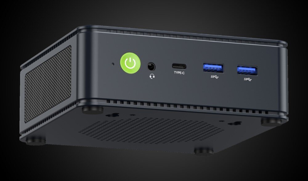 Komputer GMKTEC NucBox M5 Plus Zbliżenie na front komputera w ciemnej obudowie z zielonym przyciskiem zasilania, portem słuchawkowym, portem USB-C i dwoma portami USB, cechy, parametry