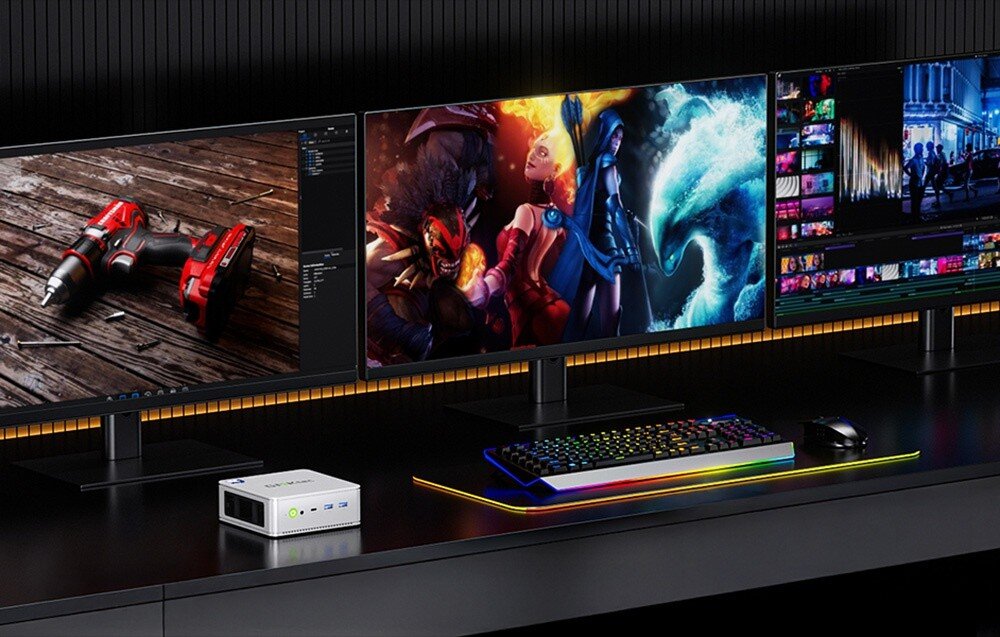Komputer GMKTEC NucBox K9 Biurko z trzema monitorami wyświetlającymi narzędzia graficzne, grę oraz edycję wideo, obok klawiatura z podświetleniem i mysz, na biurku srebrny mini komputer, ekrany, obraz, rozdzielczość